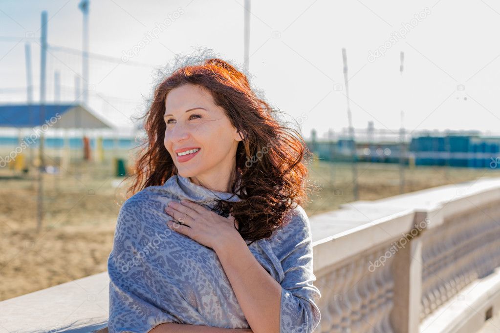 menopausal woman looking  at her side with beach in background
