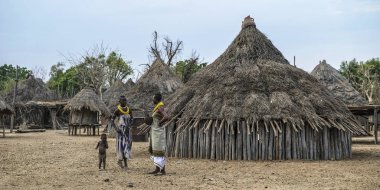 OMO Vadisi, Etiyopya - 26 Ocak: İki kimliği belirsiz kadın köylerine arka planda Karo tipik evleri ile 26 Ocak 2018 Omo Vadisi, Etiyopya konuşan Karo kabilesinin.