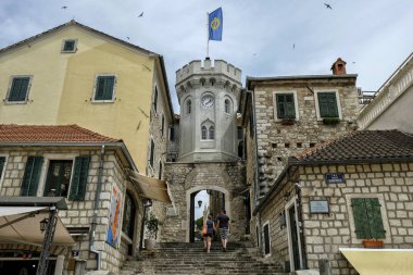 Herceg Novi - Haziran 2019: 22 Haziran 2019 'da Karadağ' ın Herceg Novi kentinde eski evlerle çevrili küçük saat kulesiyle eski kasaba kapısında turistler.