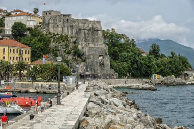 Herceg Novi, Karadağ - Haziran 2019: 22 Haziran 2019 'da Karadağ' ın Herceg Novi kentinde bulunan ünlü Deniz Kalesi yakınlarındaki gezinti alanında kimliği belirsiz insanlar yürüyor.