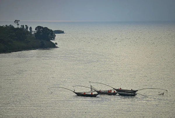 太陽の水への反射によって湖でカヌーを釣ります ルワンダのキヴ湖 キヴ湖はルワンダとコンゴ民主共和国によって共有されている ストック写真