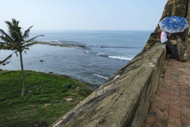 Galle, Sri Lanka - Ocak 2020: Galle, Sri Lanka 'da 14 Ocak 2020 tarihinde Galle Kalesi' nin duvarlarında genç bir çift şemsiye ile kaplandı.