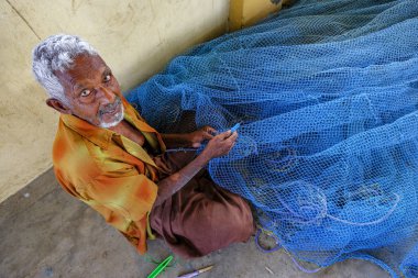 Jaffna, Sri Lanka - February 2020: A man repairing nets in the fishing district of Jaffna on February 23, 2020 in Jaffna, Sri Lanka.