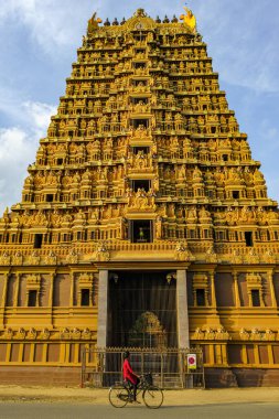 Jaffna, Sri Lanka - February 2020: A woman on a bicycle passing in front of the Nallur Kandaswamy Kovil Hindu temple on February 23, 2020 in Jaffna, Sri Lanka.