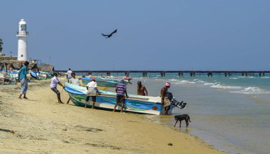 Talaimannar, Sri Lanka - February 2020: Fishermen taking the boat out of the water on February 26, 2020 in Talaimannar, Sri Lanka.