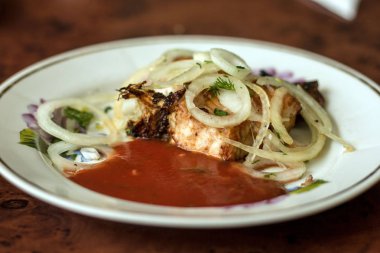 Tabağında soğan turşusu olan yayın balığından bir parça şiş kebap.