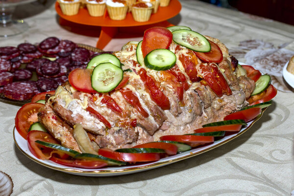праздничное блюдо, запеченное фаршированное мясо с овощами и сыром, украшенное ломтиками помидоров и огурцов, мясо аккордеона
