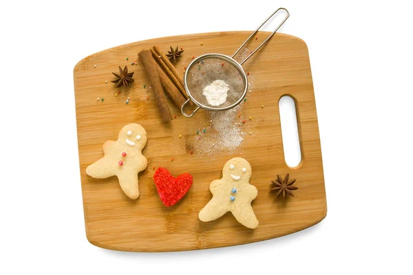 Baked men and red heart on the Board isolated on a white background.