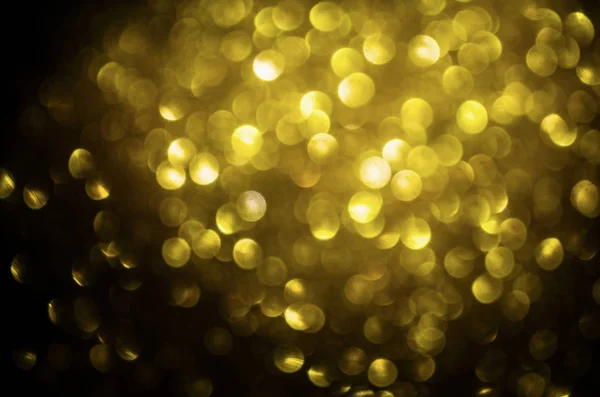 Christmas Golden circle bokeh on black background. Holiday texture for art design