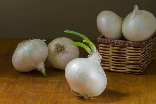 White onion in basket on wooden table background
