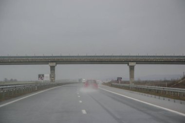 Otoyolda bir köprünün altından geçmek, yağmurlu günler, fırtınadan çıkan suda araba kullanmak, kötü hava.