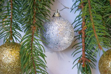 Parlak Noel oyuncakları, parıltılı toplar, beyaz arka planda çam ağacı dalları.