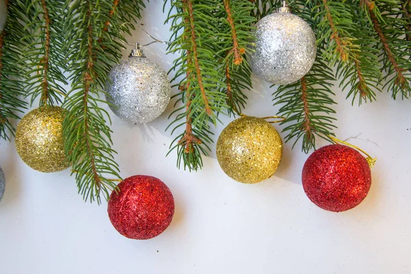闪亮的圣诞玩具 闪闪发光的球 白色背景的松树树枝 — 图库照片