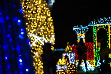Gecenin karanlığındaki Noel ışıklarının soyut bulanık görüntüsü. Arkaplan için parlak ışıklar, xmas tatil dokusu