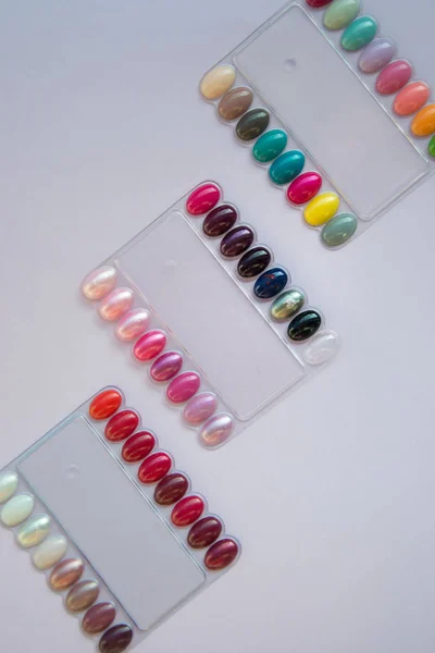 Multicolored nail polish samples, color palette in beauty salon. Manicure, fashion and stylish colors. Top view, flat lay