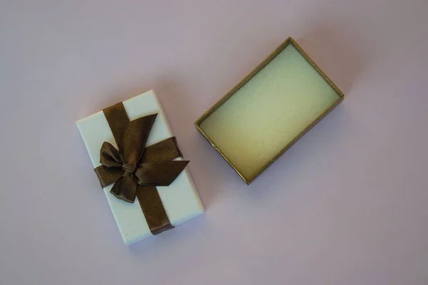 Close-up of opened box with ribbon, present, gift for the holidays, purple background