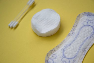 Sarı arka planda çiçek temizleme pedi, makyaj için pamuk tokaları ve pedler, hijyen konsepti, kadın ürünleri, izole edilmiş