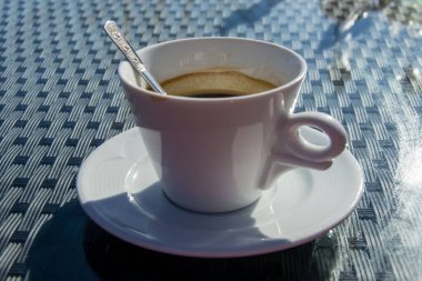 Bir fincan kahve, sıcak bir içecek ve arka planda dağ.