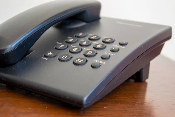 木制背景的新的现代黑色电话 桌子上的电话 办公室里的商业概念 — 图库照片