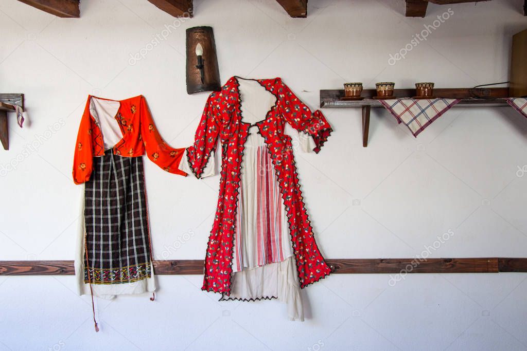 Smilen, Bulgaria - Indoor interior of old bulgarian house, ethnography, traditional costumes from Bulgaria, hanged on a wall