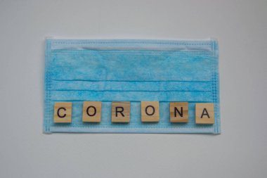Corona harfli tahta bloklar ve temiz bir maske, beyaz arka planda izole edilmiş, covid-10 salgını, Crown virüs salgını, sağlık ve tıbbi konsept