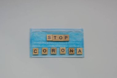 Corona harfli tahta bloklar ve temiz bir maske, beyaz arka planda izole edilmiş, covid-10 salgını, Crown virüs salgını, sağlık ve tıbbi konsept