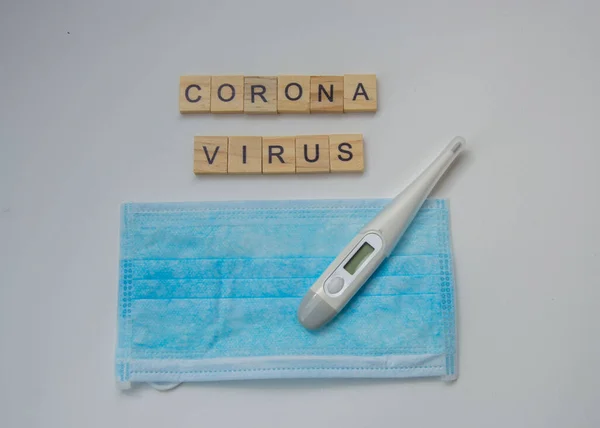 Beyaz arka plan, covid-10 salgını, Crown virüsü, termometre ve maske, sağlık ve tıbbi konsept üzerine izole edilmiş CORONA VIRUS harfli tahta fayanslar
