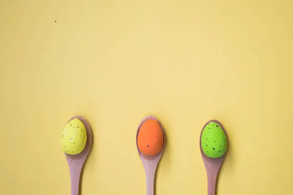 Three Colorful Easter Eggs Pale Yellow Background Egg Wooden Spoons — Stock Photo, Image