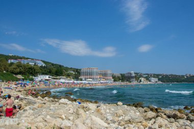 İnsanlar sıcak havanın, plaj eğlencesinin, plajda otellerin olduğu tatil yerlerinin, yaz mevsiminin tadını çıkarıyorlar.