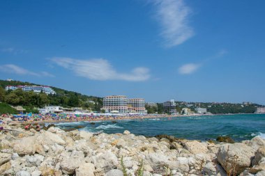 İnsanlar sıcak havanın, plaj eğlencesinin, plajda otellerin olduğu tatil yerlerinin, yaz mevsiminin tadını çıkarıyorlar.