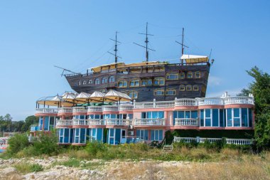 Terk edilmiş bir otelin tepesinde gerçek bir tekne, yazlık tatil beldesi, mavi gökyüzü, yaz, tatil beldesi.