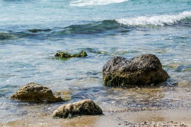 Güzel vahşi sahil manzarası, güneşli bir gün, kayalıklara vuran su dalgaları, yaz manzarası, kayalar, arka plan.