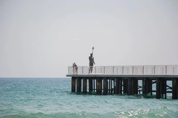 Gente Caminando Sobre Muelle Con Estatua Poseidón Puente Cerca Playa —  Fotos de Stock