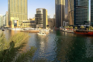 Dubai / Uae - 7 Kasım 2019: Marina Mall ile Dubai Marina lüks turistik bölgesi ve yatlı göl, ön planda palmiye yaprakları. Dubai Marina.