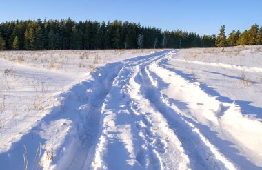 Car traces in a deep snow of remote rural area 