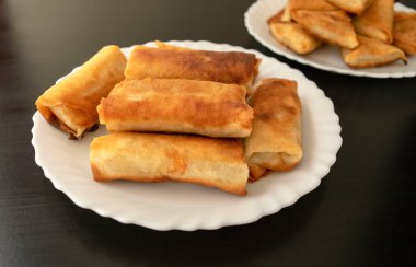 Ünlü geleneksel Orta Doğu, Asya mutfağı. Sebzeli börek ve siyah ahşap arka planda mini samosa. Beyaz tabakta bir sürü börek var. Üst görünüm 