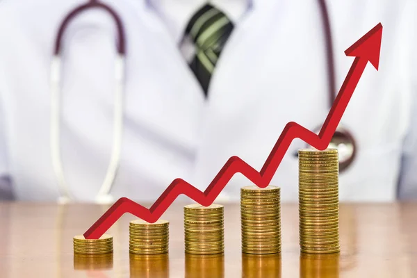 Bir grafik üzerinde ahşap olarak düzenlenmiş para sikke yığını üzerinde kırmızı ok 