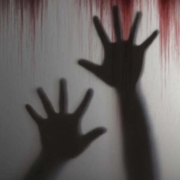 Ombre flou de l'homme main derrière un objet transparent avec sanglant — Photo
