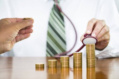 Para COI yığını kontrol stetoskop tutan işadamı el