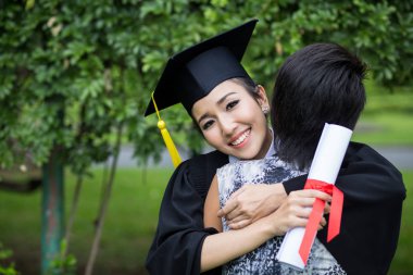 Mezuniyet töreninde annesini kucaklayan genç bir bayan.