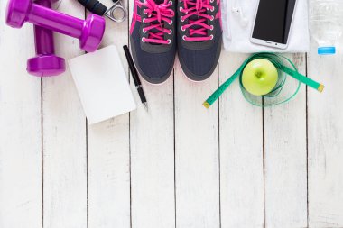 Sağlıklı spor konsepti, spor ayakkabıları, elma, su ve ahşap arka planda akıllı telefon, üst manzara