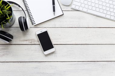 Bilgisayarlı ve tahta masadaki boş defterli üst görünüm akıllı telefon