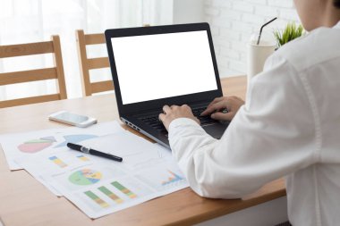 İş bilgisayarı ahşap masada çalışıyor, boş defter