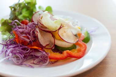 Beyaz tabakta sebze salatası.