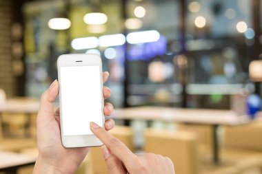 Kadın eli kahve dükkanının arka planında akıllı telefon kullanıyor.