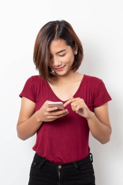 Beyaz arka planda izole edilmiş akıllı telefon kullanan Asyalı genç kadın portresi