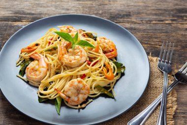 Tahta arka planda siyah tabakta spagetti. en üstteki görünüm