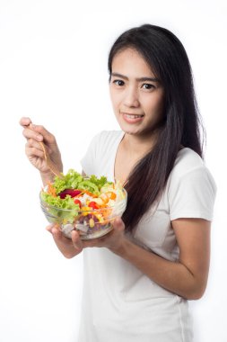 Beyaz arka plan üzerinde izole sebze salatası yiyen güzel Asya genç kadın Portresi.