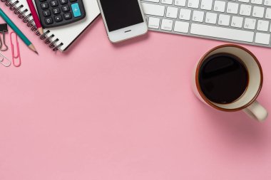 Akıllı telefon, bilgisayar ve ofis malzemeleriyle dolu en üst düzey ofis masası.