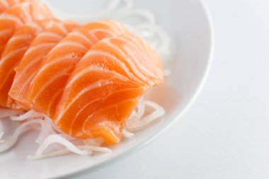 Somon balığı, beyaz arka planda bir tabakta çiğ.